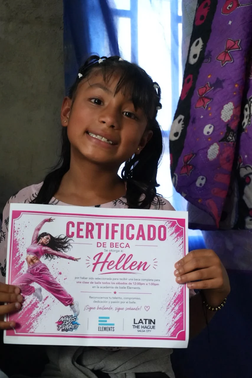 Hellen con el certificado de su beca de baile.